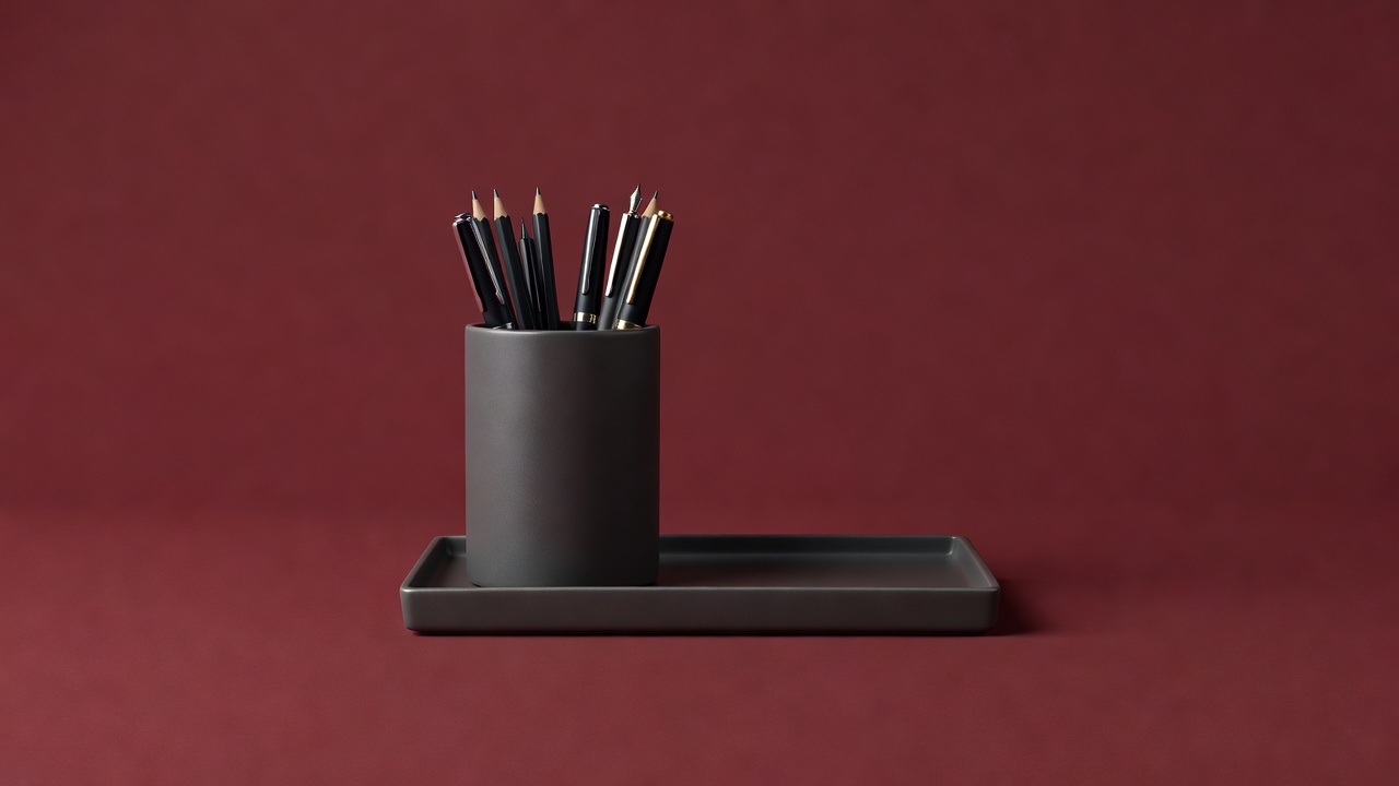 Pen cup and tray on a plain burgundy backdrop, soft-lit 3D render